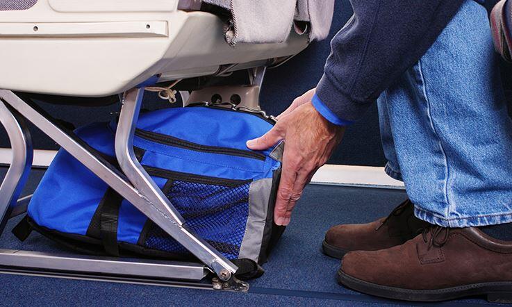 Gepäck unter dem Sitz im Flugzeug